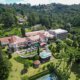 Vista aérea do Hotel Vila Inglesa em Campos do Jordão, destacando a arquitetura clássica rodeada pela natureza da Serra da Mantiqueira.