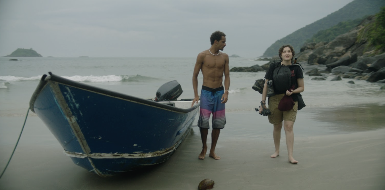 No filme dois personagens caminham pela praia do Guarujá.